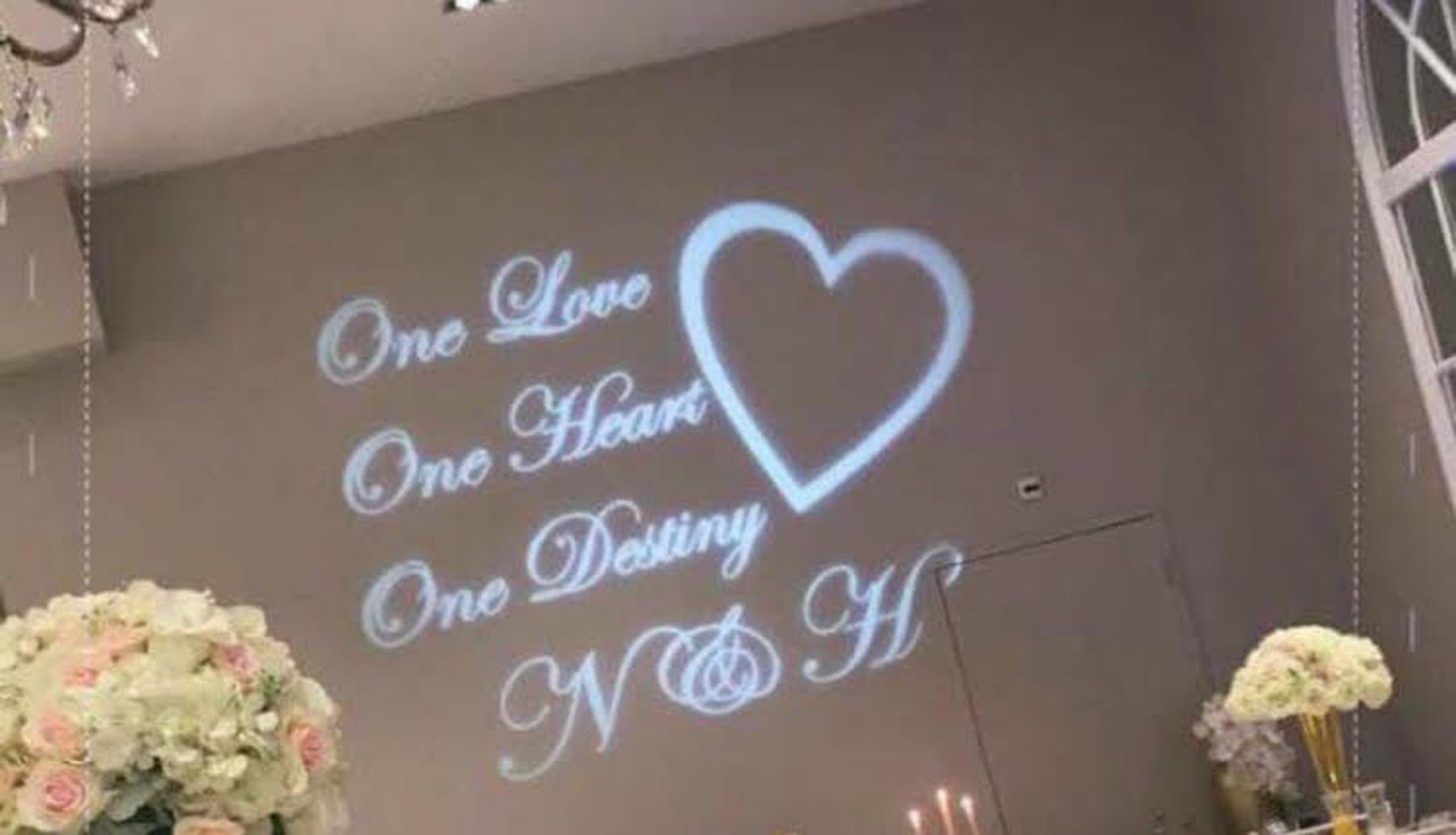 Gobo-projectie op een wand: One Love, One Heart, One Destiny met een hart en de initialen N & H